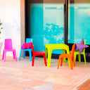 Conjunto Infantil Julieta con mesa naranja y 4 sillas multicolor para niños.