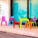 Conjunto Infantil Julieta con mesa naranja y 4 sillas multicolor para niños.